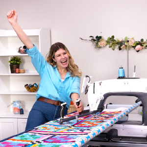 Woman celebrating while longarm quilting