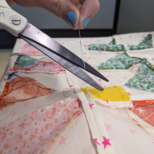 You should cut loose threads before you begin longarm quilting.